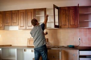 Man arranging kitchen cabinet