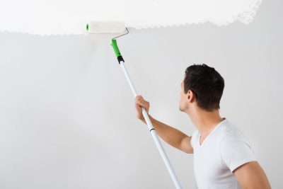 Man Painting Wall With Paint Roller - Turnkey Painters